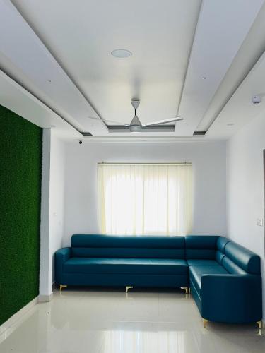 a living room with a blue couch and a window at Hotel Rama in Gorakhpur