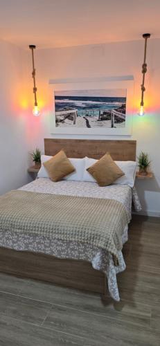 a bedroom with a bed with a painting on the wall at Vivienda Turística Playa El Portil in El Portil