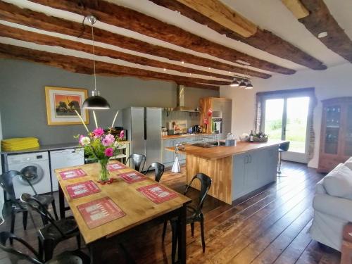 une cuisine et une salle à manger avec une table et des chaises dans l'établissement Fermette La Trappe, à Saint-Priest-Ligoure