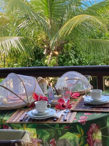 einen Tisch mit Teller und Tassen oben in der Unterkunft Espelho Bahia Blue House in Praia do Espelho