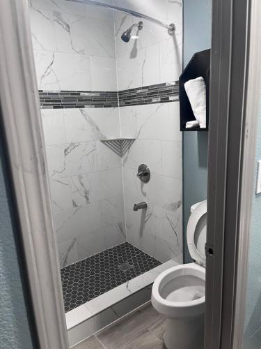 a bathroom with a shower with a toilet at Ozark Inn in Mena