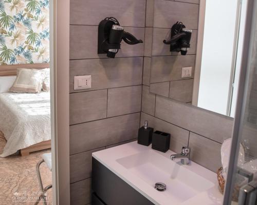 a bathroom with a sink and a mirror and a bed at B&B La Terrazza sui Colli in Rome