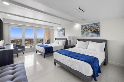 a bedroom with two beds and a living room at Stunning Sunsets and SpaceX Views in South Padre Island