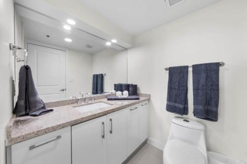 a bathroom with a toilet and a sink and a mirror at Stunning Sunsets and SpaceX Views in South Padre Island