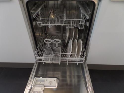 a dishwasher filled with lots of dishes and glasses at MAFF Top Studio Apartment in The Hague
