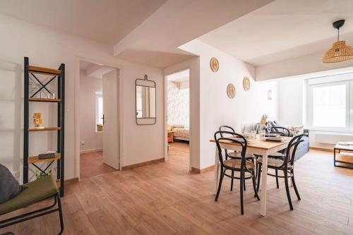 une salle à manger et un salon avec une table et des chaises dans l'établissement Jeroboam Fauvette, bel appartement hyper centre Epernay, à Épernay
