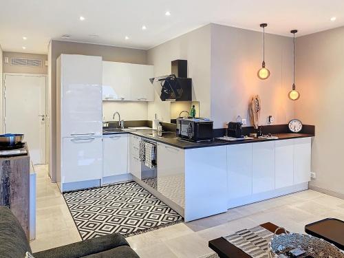 une cuisine avec des armoires blanches et un comptoir dans l'établissement 2Pièces Marina Baie des Anges, à Villeneuve-Loubet