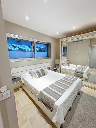une chambre avec un grand lit et une grande fenêtre dans l'établissement 2Pièces Marina Baie des Anges, à Villeneuve-Loubet