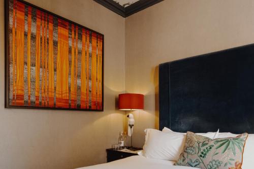 a bedroom with a bed and a painting on the wall at No 15 by GuestHouse, Bath in Bath