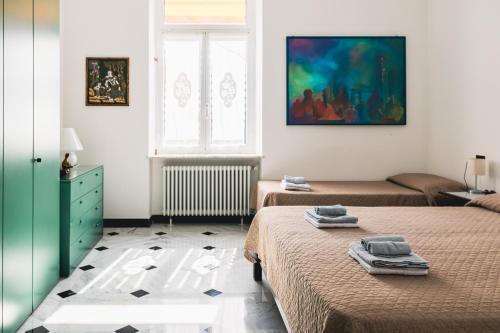 a bedroom with two beds and a painting on the wall at palmaria suite -the duck nest in Genoa