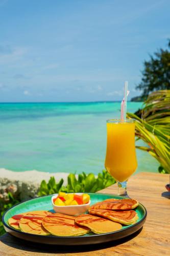 a plate of food on a table with a drink at Salida Beach Zanzibar in Kizimkazi