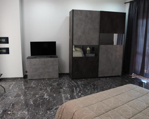 a bedroom with a bed and a dresser with a television at B&B La Terrazza sui Colli in Rome