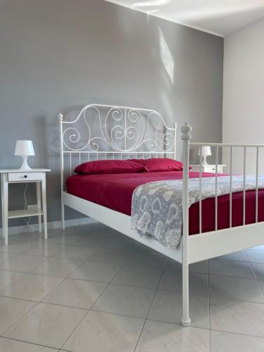 1 dormitorio con cama blanca y manta roja en Elysium Etna Rooftop, en Fiumefreddo di Sicilia