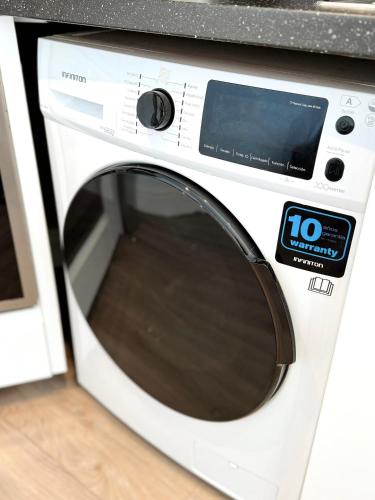 a white microwave oven sitting in a kitchen at Modern City Centre Two Bedroom Windsor Apartment - Grand Central House in Gibraltar