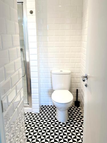 a bathroom with a toilet and a black and white tile floor at Modern City Centre Two Bedroom Windsor Apartment - Grand Central House in Gibraltar
