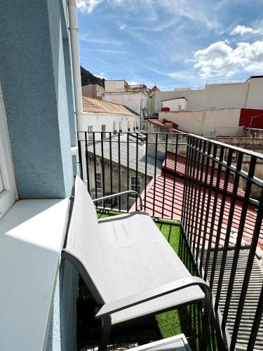 a white bench sitting on the balcony of a building at Modern City Centre Two Bedroom Windsor Apartment - Grand Central House in Gibraltar