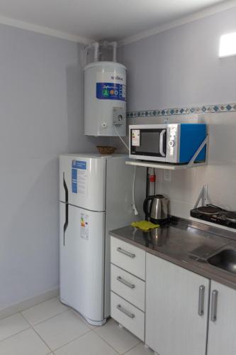 a small kitchen with a refrigerator and a microwave at Departamentos La Justina in Cafayate