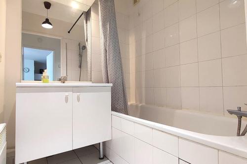 une salle de bain blanche avec un lavabo et une baignoire dans l'établissement Agréable T2 avec terrasse Proche gare, à Brétigny-sur-Orge