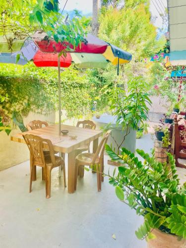 a wooden table with chairs and an umbrella at Nimal's House in Dickwella