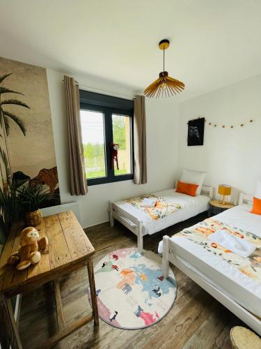 un salon avec deux lits et une table dans l'établissement Maison plain-pied, à Chamadelle