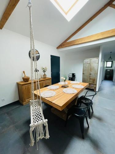 - une balançoire dans une chambre avec une table et des chaises dans l'établissement Maison plain-pied, à Chamadelle