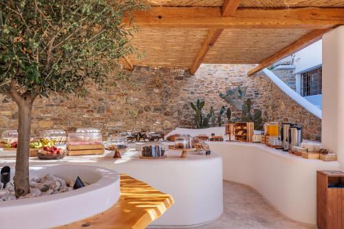 a cafe with a tree in the middle of a room at Evlalia Studios & Villas in Skopelos Town
