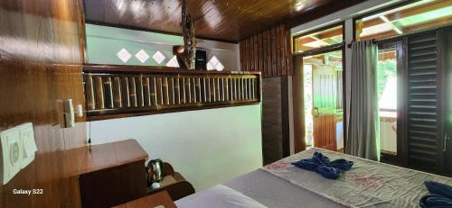 a bedroom with a bed and a balcony at Sam's Bungalows And Treks in Bukit Lawang