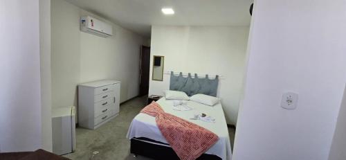 a small bedroom with a bed and a dresser at Pousada Pé Na Areia in Arraial do Cabo