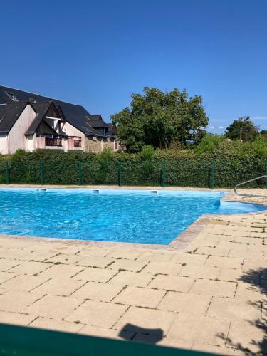 a swimming pool with blue water in front of a house at Les SARDINES BLEUES pour 2 à 4 vacanciers in Carnac