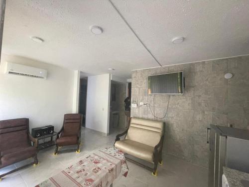 a waiting room with two chairs and a tv on the wall at Condominio Bahía Solero Girardot in Ricaurte