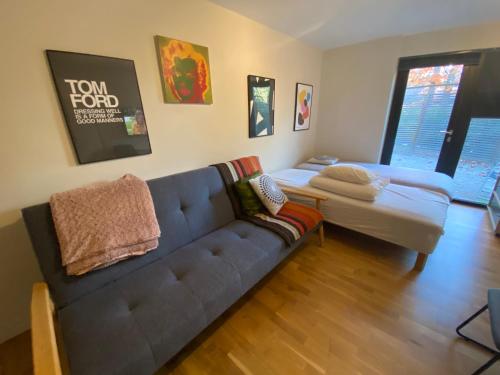 a living room with a couch and a bed at townhouse on Arlanda Stockholm metro line - easy checkin in Sollentuna