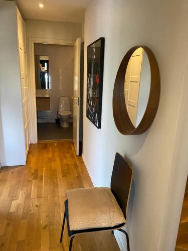 a bathroom with a chair and a mirror on a wall at townhouse on Arlanda Stockholm metro line - easy checkin in Sollentuna