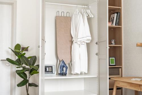 Habitación con armario con ropa blanca. en Title Halo Time for Jungle 40m2 King Bed Pool, en Nai Yang Beach