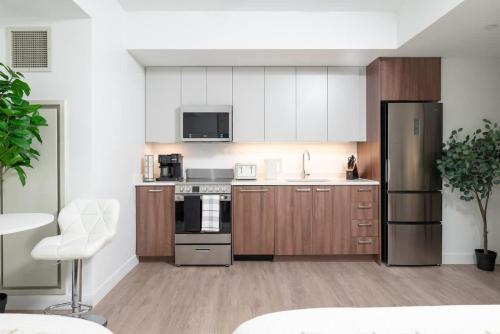 a kitchen with wooden cabinets and stainless steel appliances at Luxury Studio King bed Gym near MIT Harvard in Cambridge