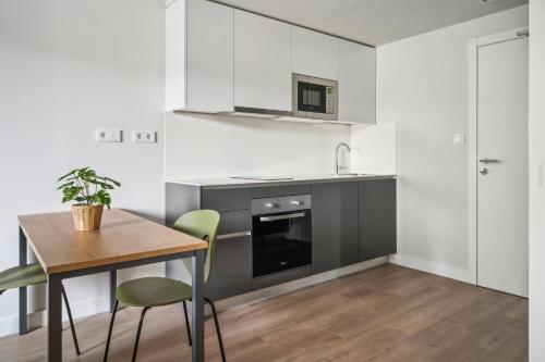 a kitchen with a table and a stove and a microwave at Truliving Vallecas by Habyt in Vallecas