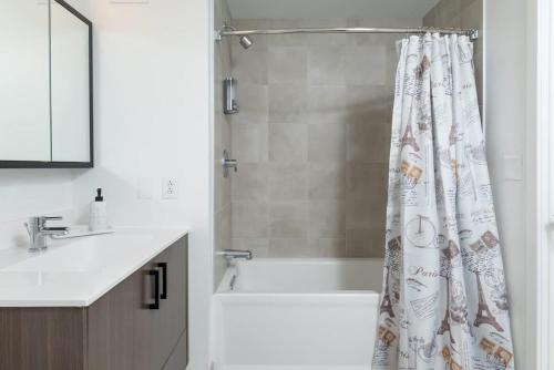 a bathroom with a tub and a shower curtain at Luxury Studio King bed Gym near MIT Harvard in Cambridge