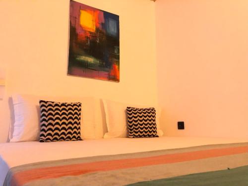 a bed with two pillows sitting on top of it at Backpack Beach Hostel & Reggae Bar in Galle