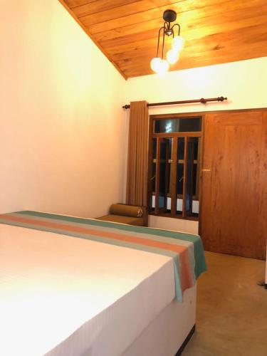 a bedroom with a bed and a wooden ceiling at Backpack Beach Hostel & Reggae Bar in Galle