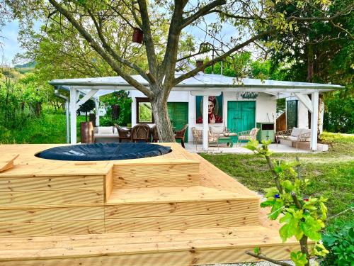 a wooden sandbox in front of a house with a tree at Bohemian ECO lodge in Kisapáti