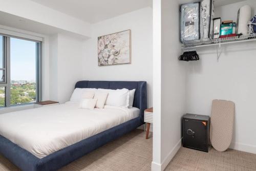 a bedroom with a blue bed and a window at Central Penthouse City Skyline Views Gym sleep 8 in Cambridge