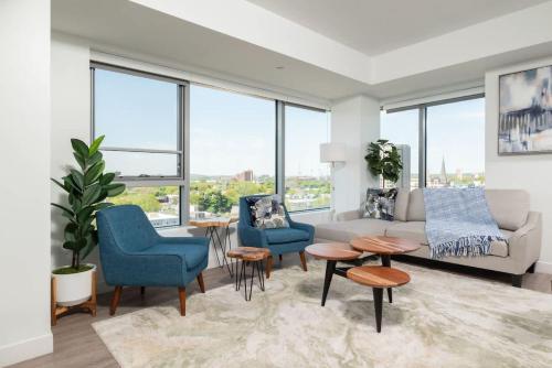 a living room with a couch and chairs and windows at Central Serene Condo King Bed by MIT Harvard GYM in Cambridge