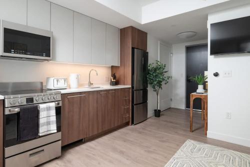a kitchen with white cabinets and a stove top oven at Lux Studio 2xQueen beds Gym near MIT Harvard in Cambridge