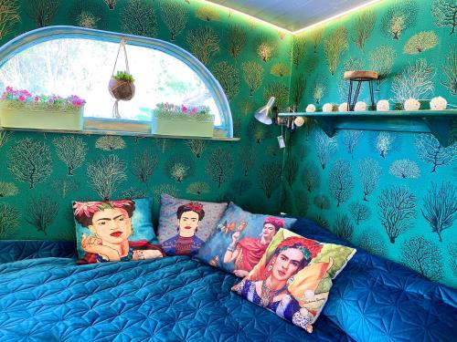 a bedroom with a blue bed with pictures on it at Bohemian ECO lodge in Kisapáti