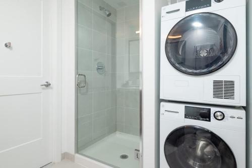 a washer and dryer in a bathroom with a shower at Lux Studio 2xQueen beds Gym near MIT Harvard in Cambridge