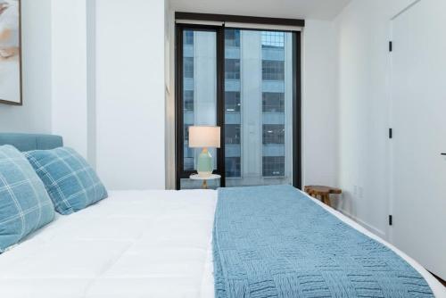 a bedroom with a large white bed with a window at Back-Bay Upscale Central Condo Bos Common Downtown in Boston