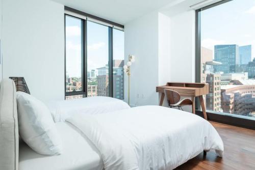 a white bedroom with two beds and a desk at Back-Bay 2BR Penthouse w Roof top and GYM in Boston