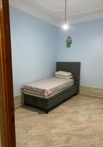 Un dormitorio con una cama en la esquina de una habitación. en منزل حديث ومريح, en Oujda