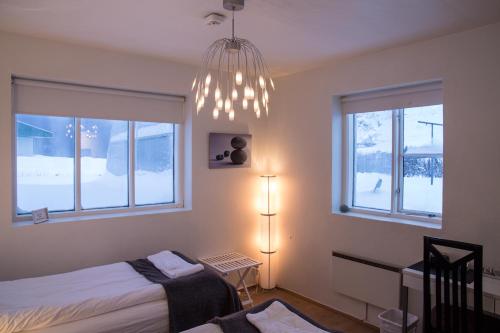 a bedroom with a bed and a chandelier at Kósý Vík in Vík