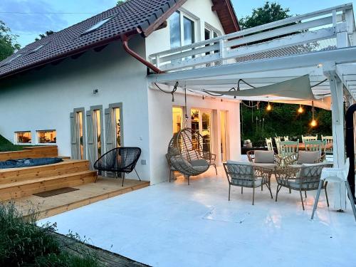 a patio with chairs and a table and an umbrella at Bohemian ECO lodge in Kisapáti