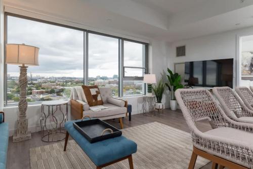 a living room with furniture and large windows at High Rise Retreat w City Skyline Views Shared Gym in Cambridge